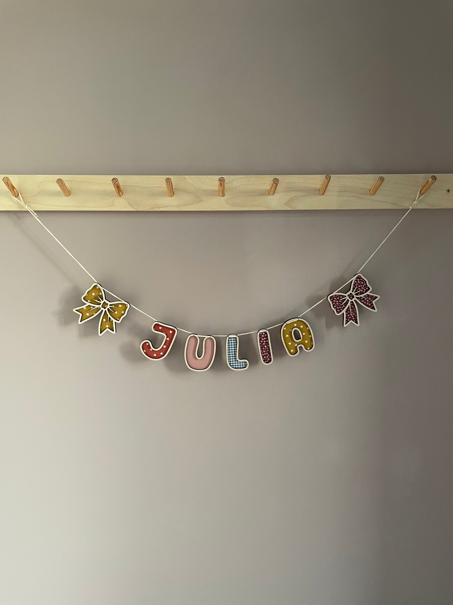 Personlig navneguirlande i træ med sløjfer - farvemix